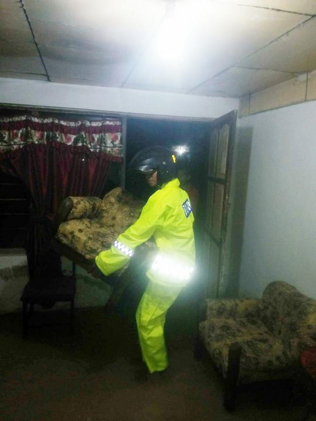 Pantau Banjir, Bhabinkamtibmas Putabangun Bantu Evakuasi Prabot Warga